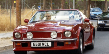 David and Victoria Beckham cruise in their red Aston Martin V8 Volante